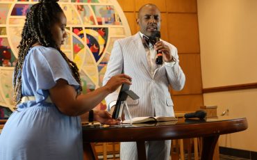 Ministers praying at the front of Leak Chapel during a service